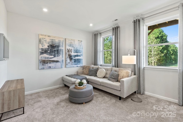 sitting room featuring baseboards, visible vents, and light colored carpet