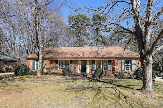 ranch-style house featuring brick siding and a front yard