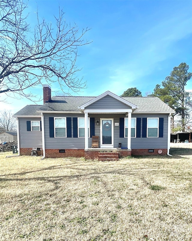 view of front of home featuring crawl space, a chimney, a front lawn, and roof with shingles