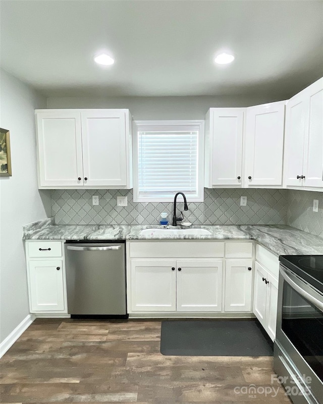 kitchen featuring dark wood-style floors, appliances with stainless steel finishes, a sink, and white cabinets