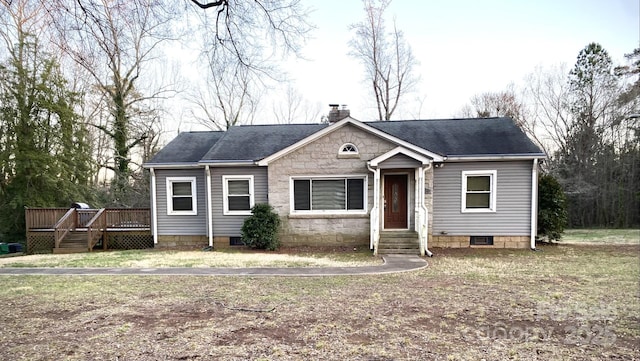 view of front facade featuring roof with shingles, a chimney, and a wooden deck