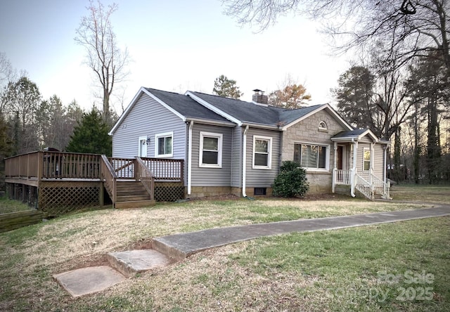 view of front of home with a front yard, stone siding, a chimney, and a wooden deck