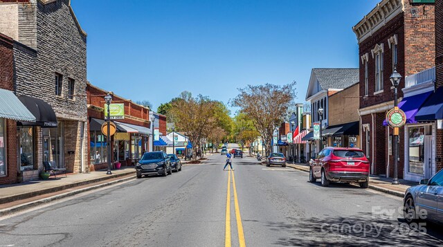 view of road featuring sidewalks, street lights, and curbs