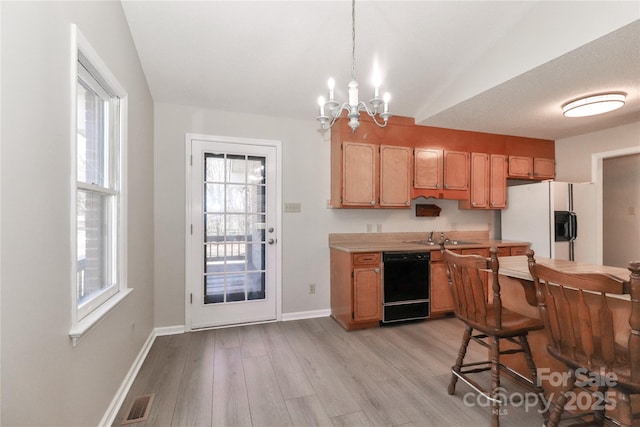 kitchen featuring white refrigerator with ice dispenser, pendant lighting, light countertops, light wood-style floors, and dishwasher