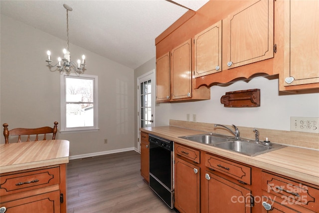 kitchen with pendant lighting, light countertops, vaulted ceiling, a sink, and dishwasher