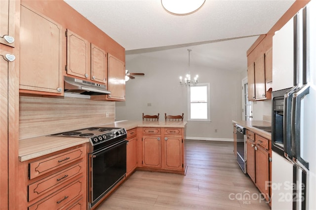 kitchen featuring electric stove, light countertops, under cabinet range hood, and a peninsula