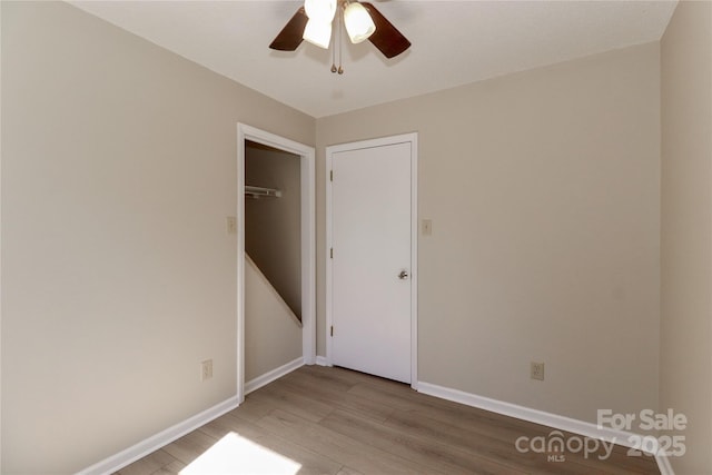 unfurnished room with a ceiling fan, baseboards, and light wood finished floors