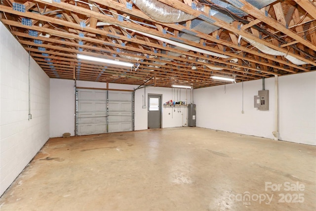 garage featuring concrete block wall, electric panel, and electric water heater