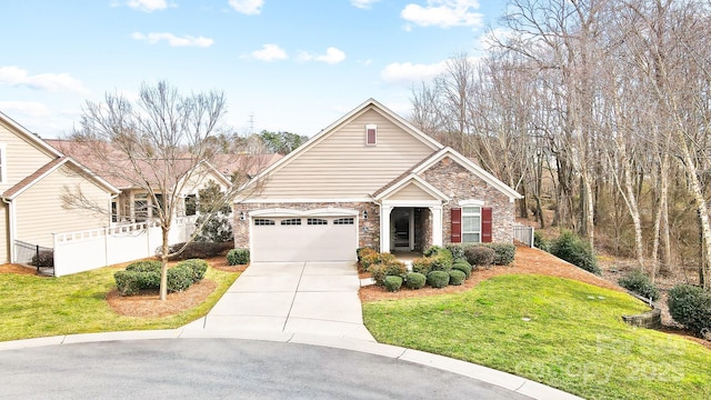 view of front of property featuring stone siding, a front lawn, fence, and driveway