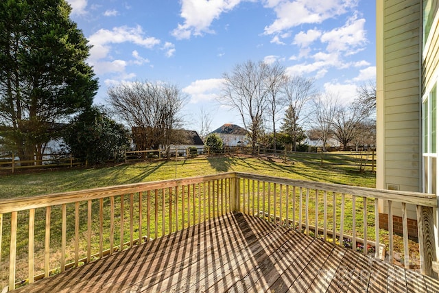 wooden deck featuring a lawn and fence