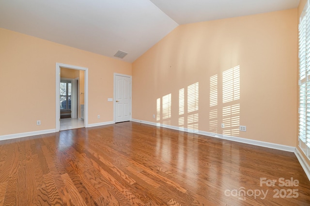 unfurnished room with high vaulted ceiling, visible vents, baseboards, and wood finished floors