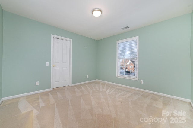 unfurnished room with baseboards, visible vents, and light colored carpet