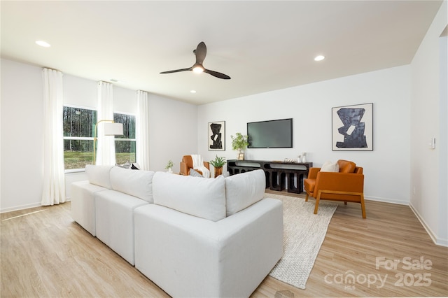 living room featuring recessed lighting, baseboards, ceiling fan, and light wood finished floors