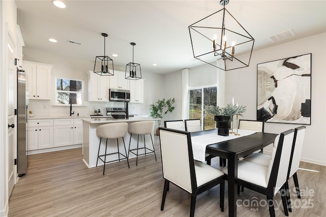 dining area featuring light wood-type flooring, visible vents, and recessed lighting