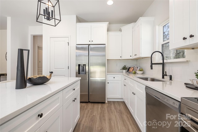 kitchen featuring stainless steel appliances, tasteful backsplash, a sink, and light countertops