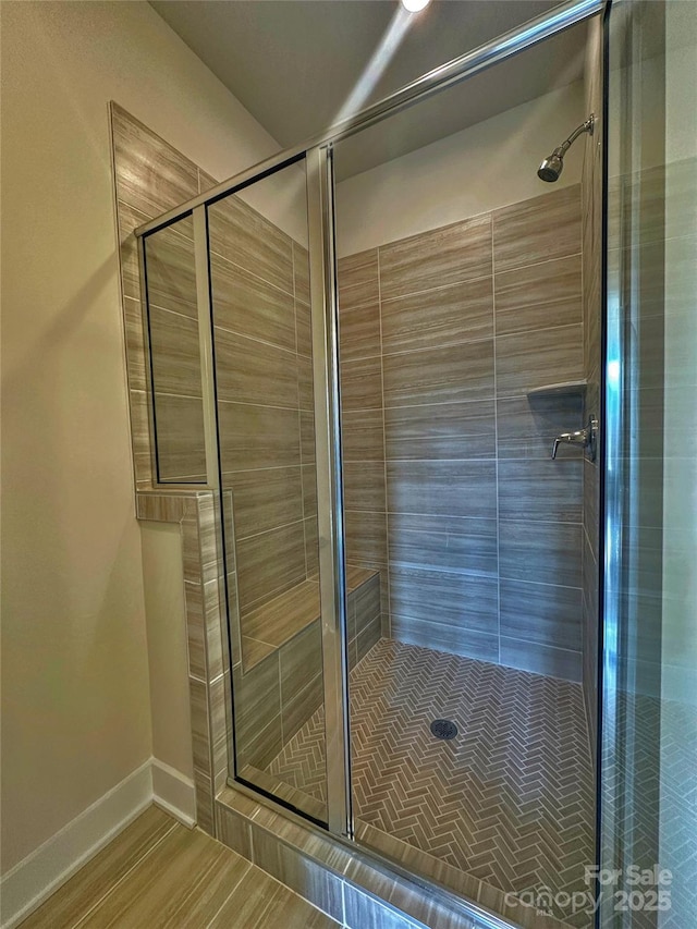 bathroom featuring a stall shower and baseboards