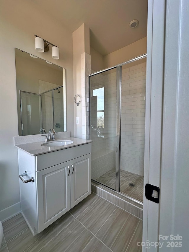 bathroom with a stall shower and vanity