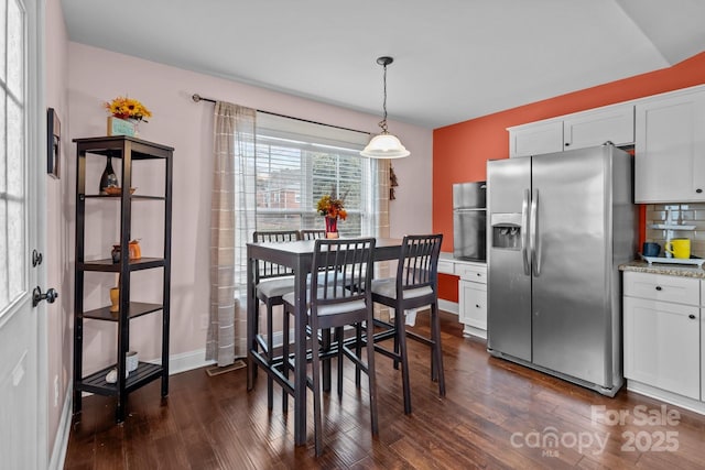 dining space featuring baseboards and dark wood-style flooring