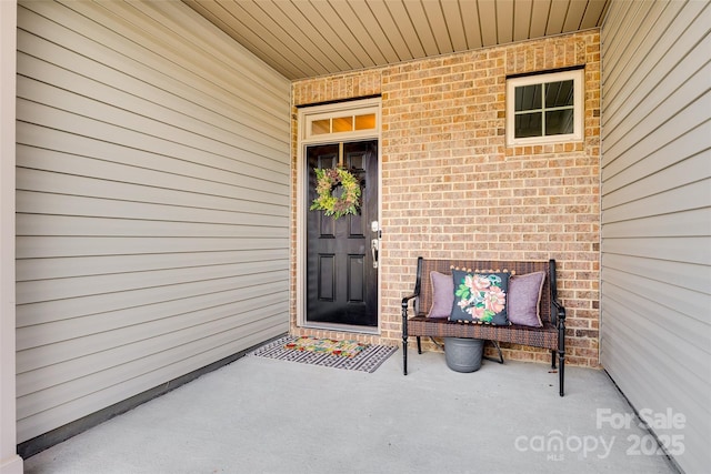 view of exterior entry featuring brick siding