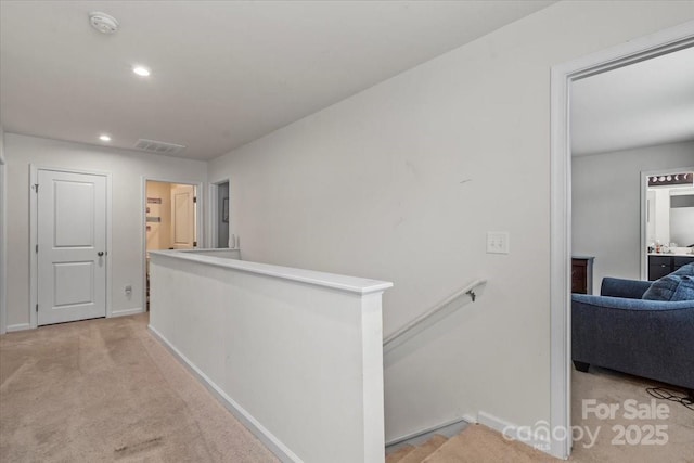 corridor featuring recessed lighting, light colored carpet, visible vents, baseboards, and an upstairs landing