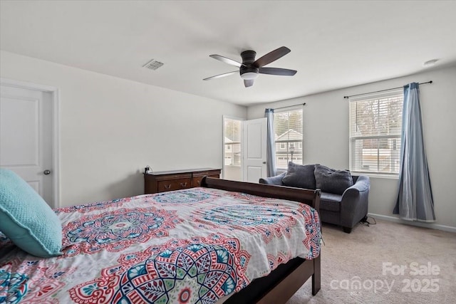 carpeted bedroom featuring a ceiling fan, visible vents, and baseboards