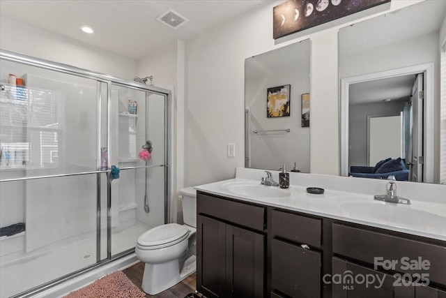 full bathroom featuring double vanity, a stall shower, a sink, and visible vents