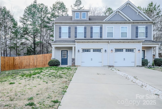 view of front of home featuring concrete driveway, board and batten siding, an attached garage, and fence