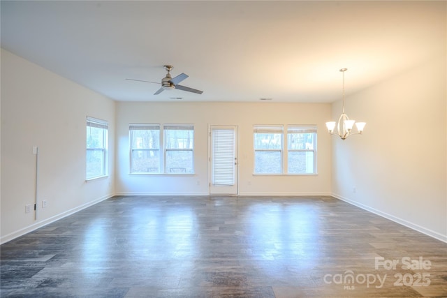 empty room with visible vents, baseboards, dark wood finished floors, and ceiling fan with notable chandelier