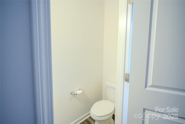 bathroom featuring wood finished floors, toilet, and baseboards