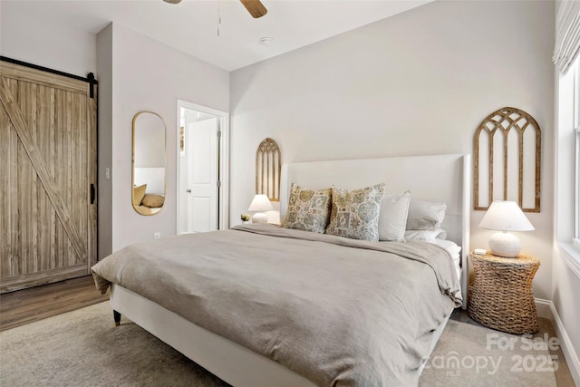 215 David Ridge Rd, Black Mountain, NC 28711 - bedroom with a barn door, baseboards, ceiling fan, and wood finished floors
