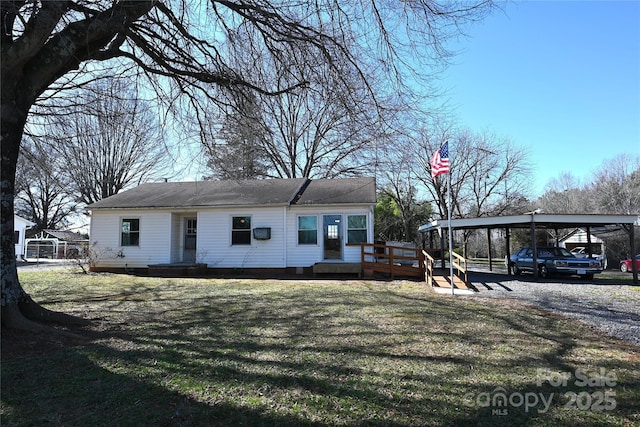 view of front of house with a detached carport, a deck, and a front lawn