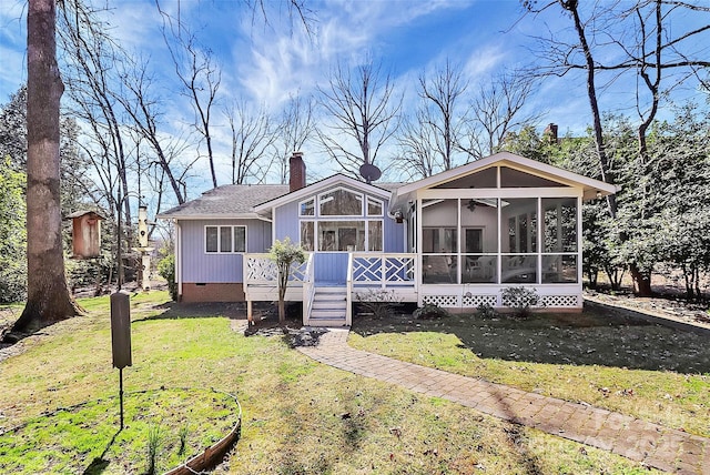 view of front of home with a chimney, a shingled roof, a front yard, a sunroom, and crawl space