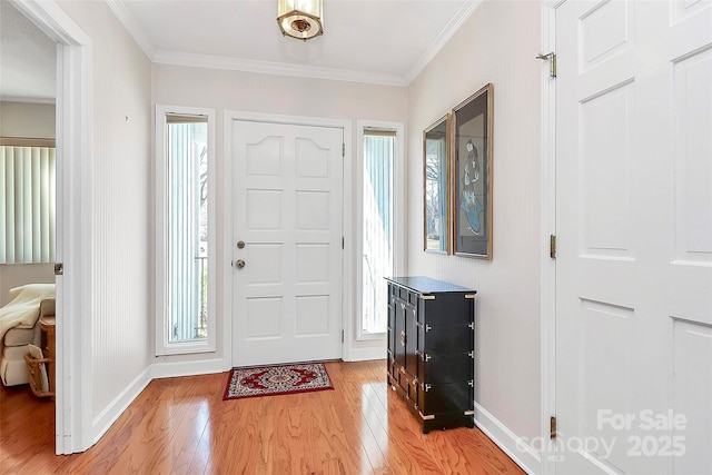 foyer entrance featuring light wood-style floors, ornamental molding, and baseboards