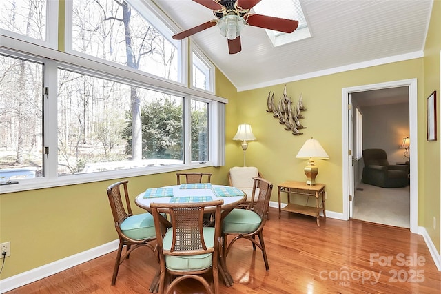 dining area with ceiling fan, high vaulted ceiling, wood finished floors, and baseboards