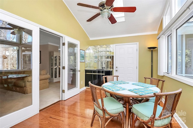 sunroom / solarium featuring lofted ceiling, a ceiling fan, and french doors