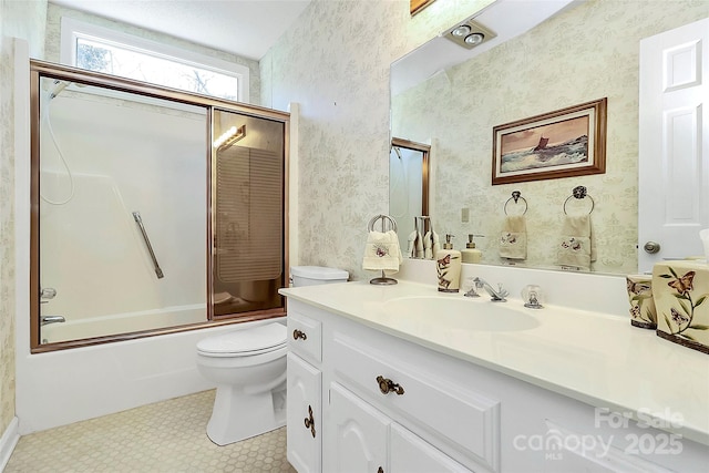 full bathroom featuring toilet, wallpapered walls, combined bath / shower with glass door, and vanity