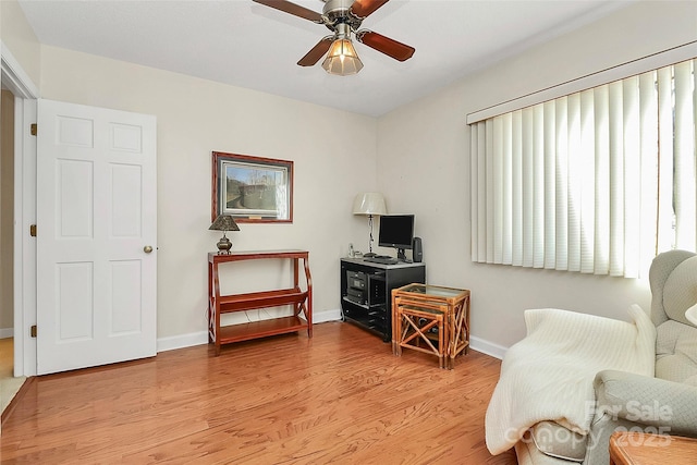 sitting room featuring ceiling fan, light wood finished floors, and baseboards