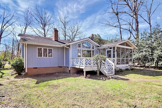 back of house with a sunroom, a yard, roof with shingles, crawl space, and a chimney