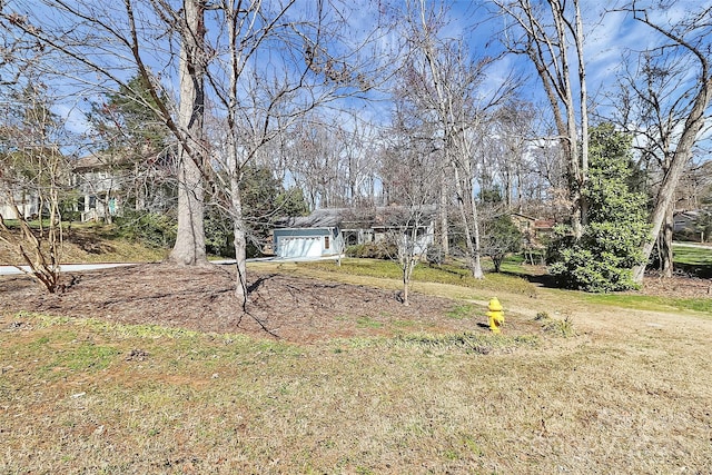 view of yard featuring driveway and a garage