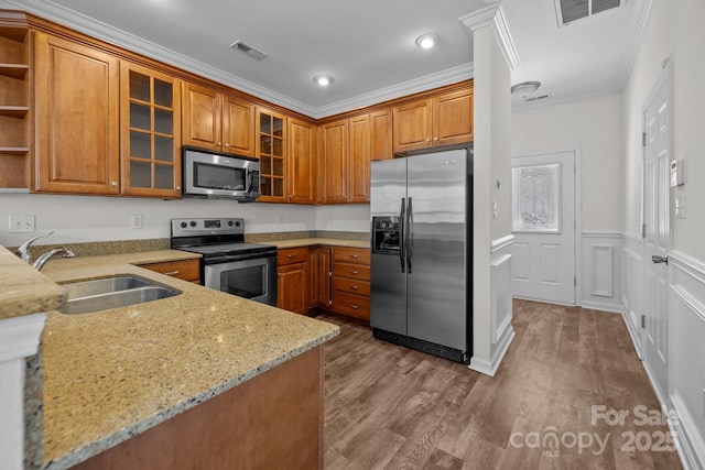 kitchen with brown cabinets, open shelves, visible vents, appliances with stainless steel finishes, and a sink