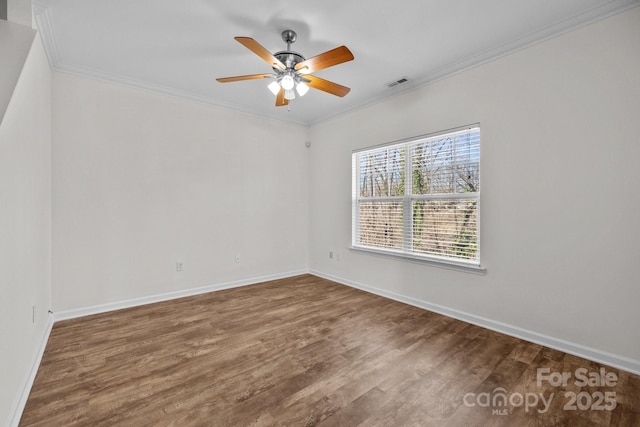 unfurnished room featuring crown molding, visible vents, a ceiling fan, wood finished floors, and baseboards