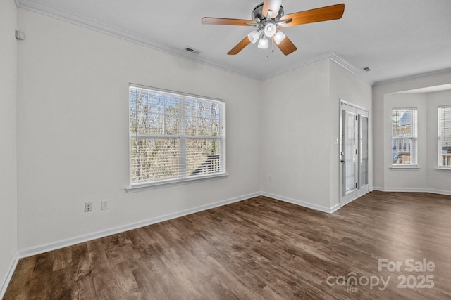 spare room featuring crown molding, dark wood-style flooring, visible vents, and baseboards