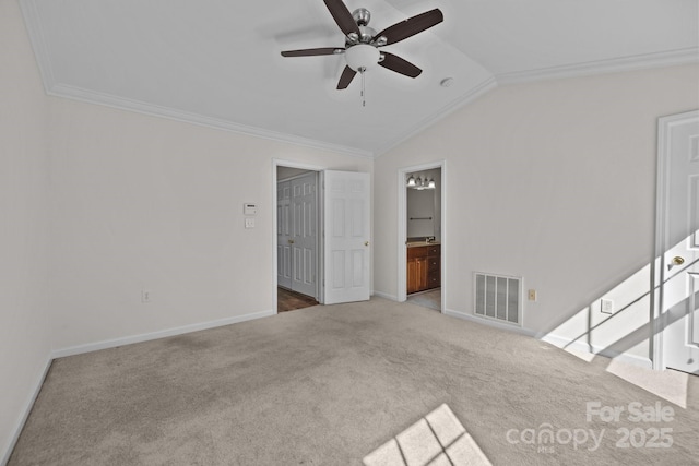 interior space with lofted ceiling, baseboards, visible vents, and ornamental molding