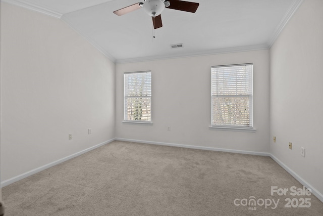 carpeted spare room featuring ceiling fan, visible vents, baseboards, vaulted ceiling, and crown molding