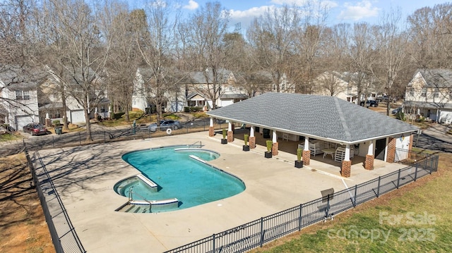 pool with a residential view, a patio, and fence