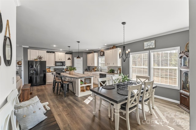 dining area featuring an inviting chandelier, crown molding, baseboards, and dark wood-style flooring