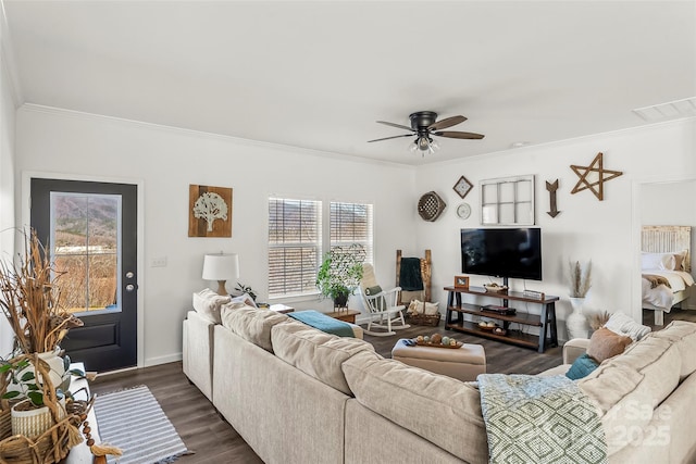 living room featuring visible vents, dark wood finished floors, baseboards, ceiling fan, and ornamental molding