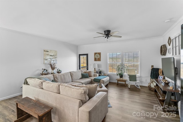 living room featuring baseboards, a ceiling fan, wood finished floors, and ornamental molding