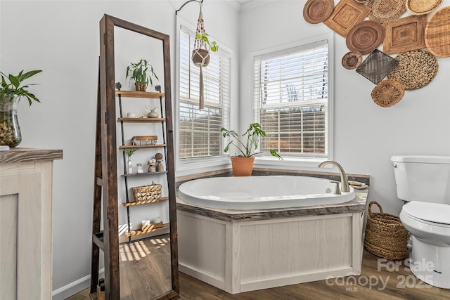 full bathroom featuring wood finished floors, a garden tub, and toilet