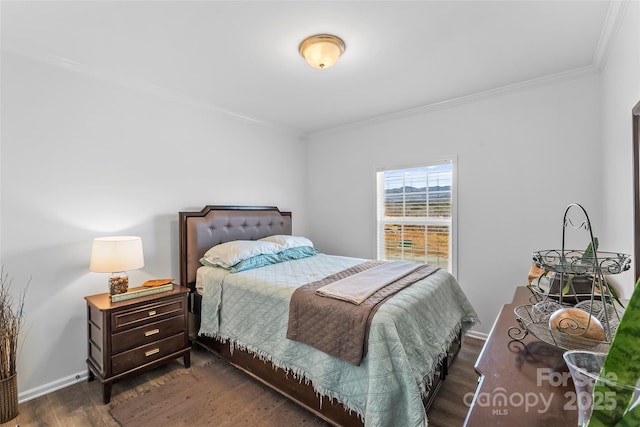 bedroom featuring baseboards, dark wood finished floors, and crown molding